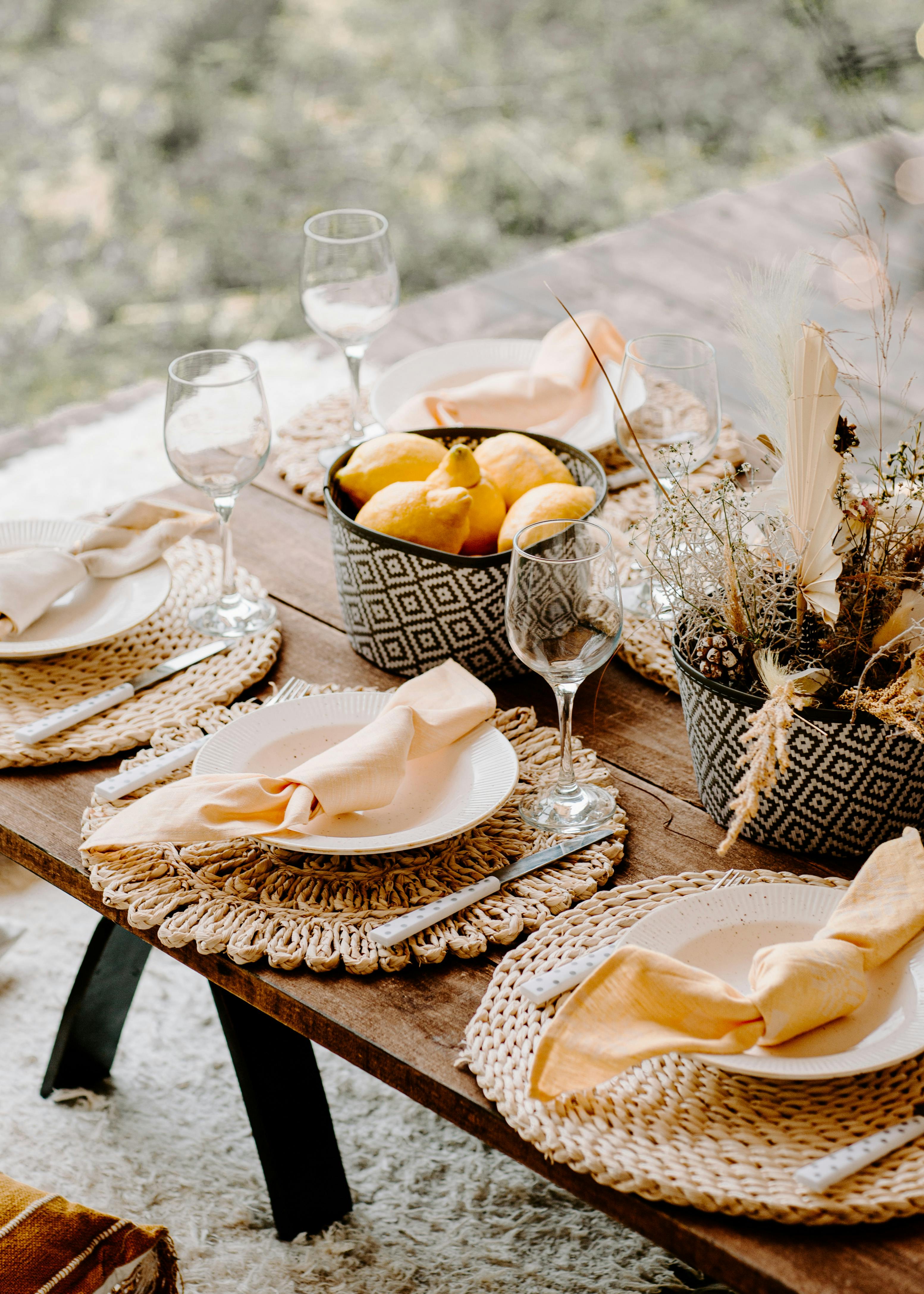 Chic rustic table setup with lemons, napkins, and glasses, ideal for outdoor dining themes.
