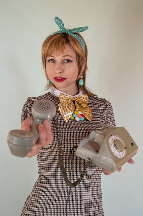 Photo of a Woman with a Blue Headband Giving the Telephone