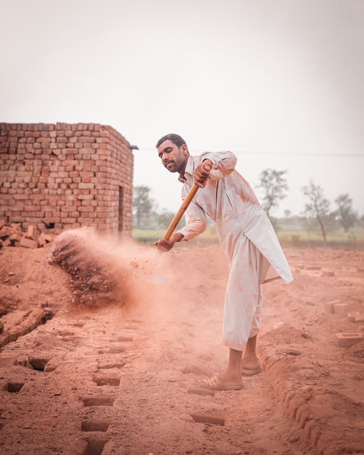 Man In White Robe Digging