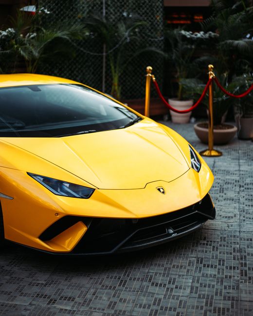 Vibrant yellow Lamborghini supercar showcased in an elegant outdoor setting with a luxurious vibe.