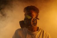 Man in White Crew Neck Shirt Wearing Gas Mask