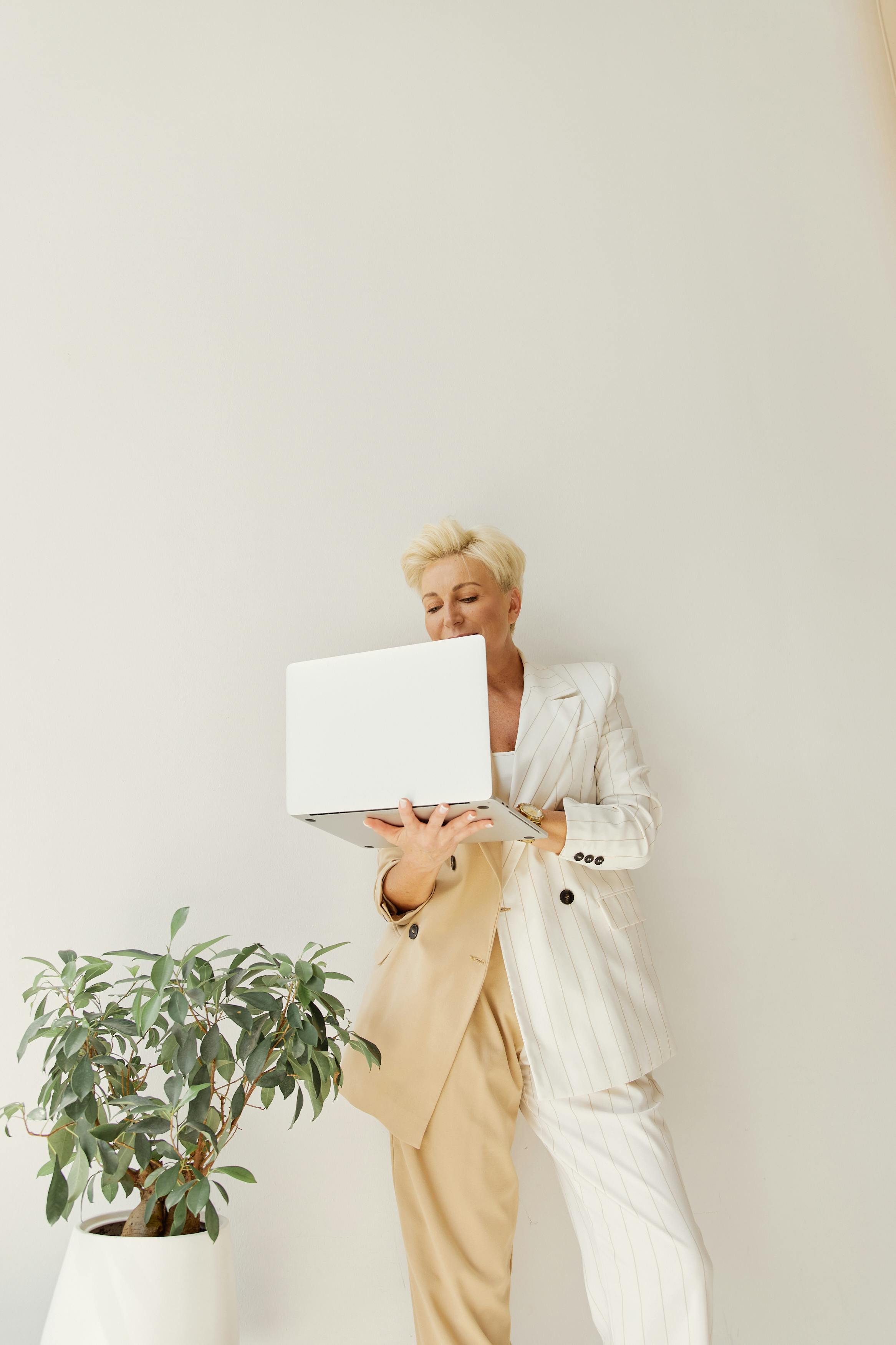 woman wearing a suit standing using laptop