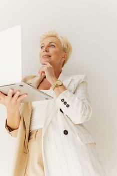 Confident blonde businesswoman with laptop contemplating ideas.