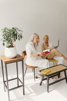 Two senior women working in a minimalist office, embodying elegance and leadership.