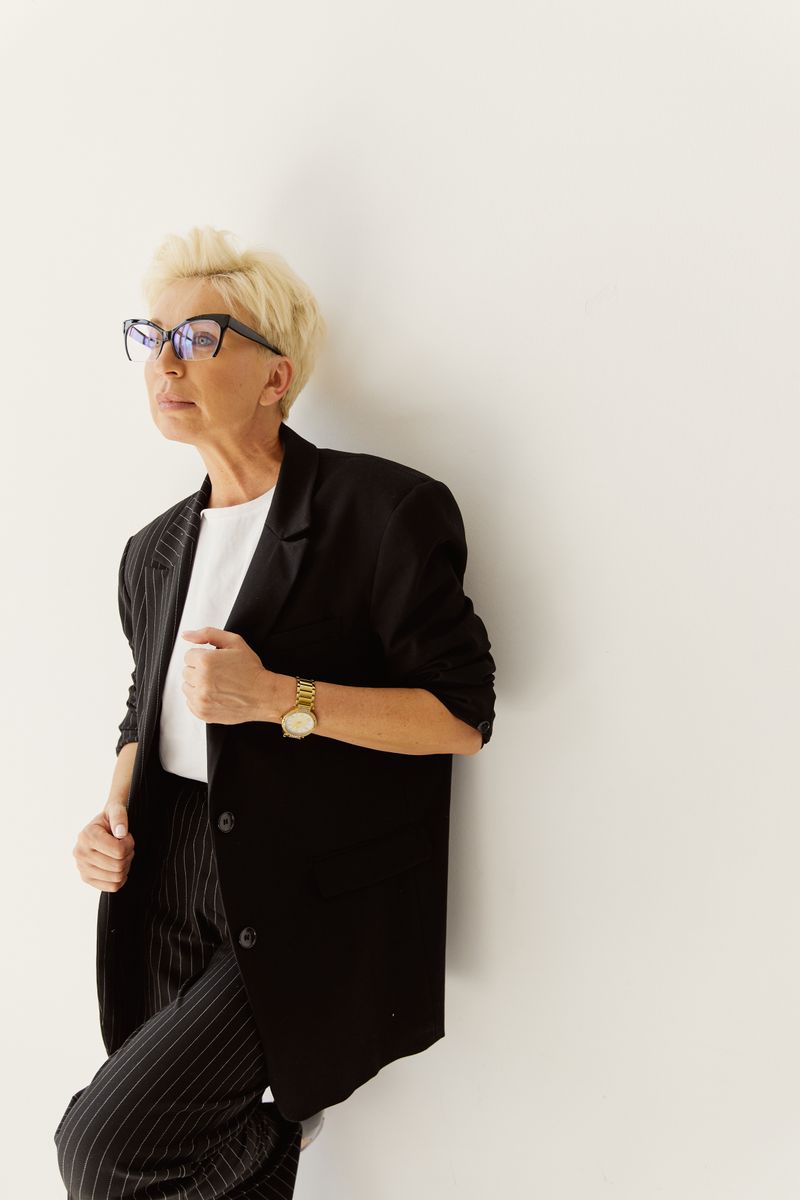 Woman in a black pinstripe suit and glasses