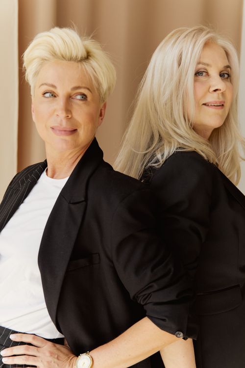 Free Chic portrait of two mature businesswomen wearing black blazers, smiling confidently. Stock Photo