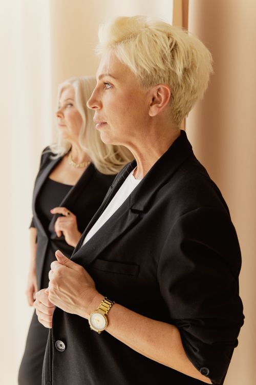Free Two mature businesswomen in suits, exuding confidence and style indoors. Stock Photo