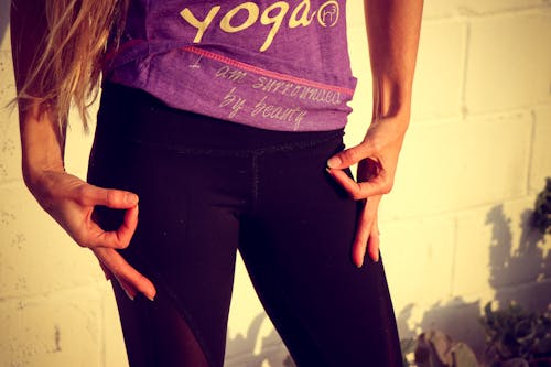 Woman Wearing Purple and White Yoga Printed Shirt and Black Bottoms