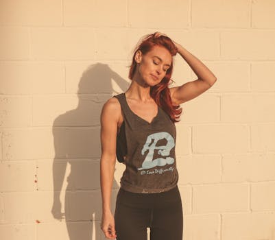 Woman in Gray and Black Tank Top Standing Near Wall