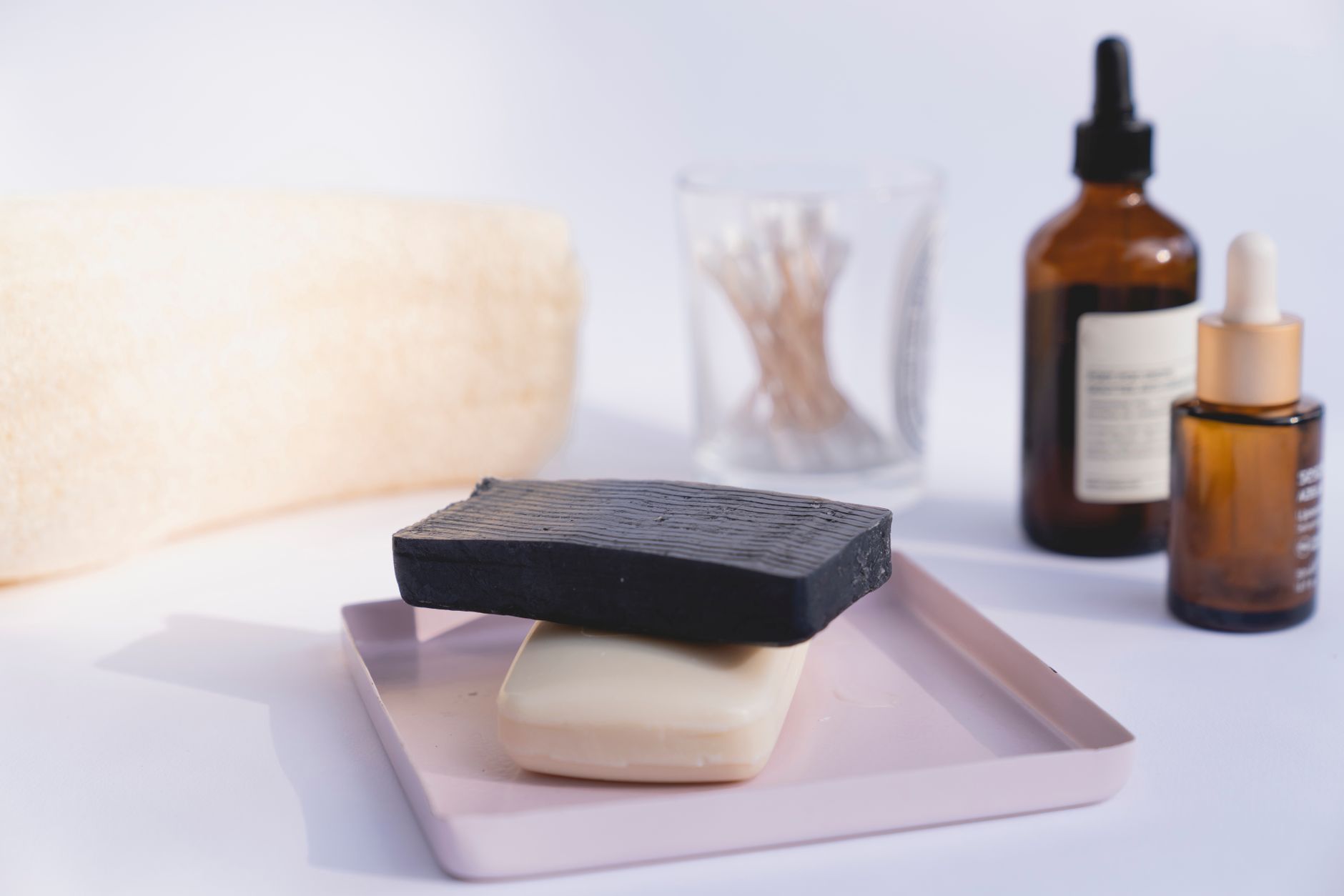 A minimalist display of skincare products including soaps and serums on a clean background.