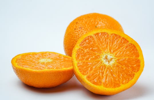 Close-up of vibrant sliced oranges on a white surface, highlighting freshness and juicy texture.