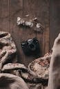 Vintage camera on wooden floor near blanket and lunaria