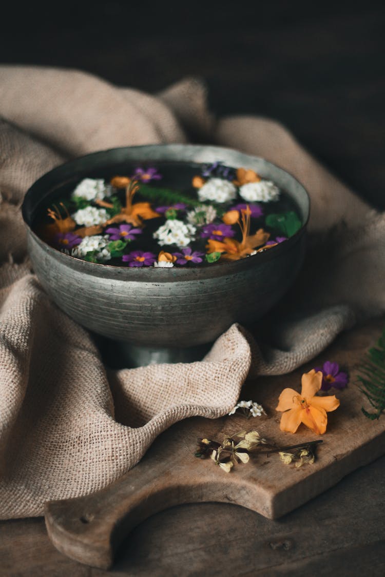 Dried Flowers On Cutting Board And In Bowl With Water