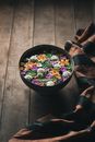 Blanket and bowl with water and flowers on floor