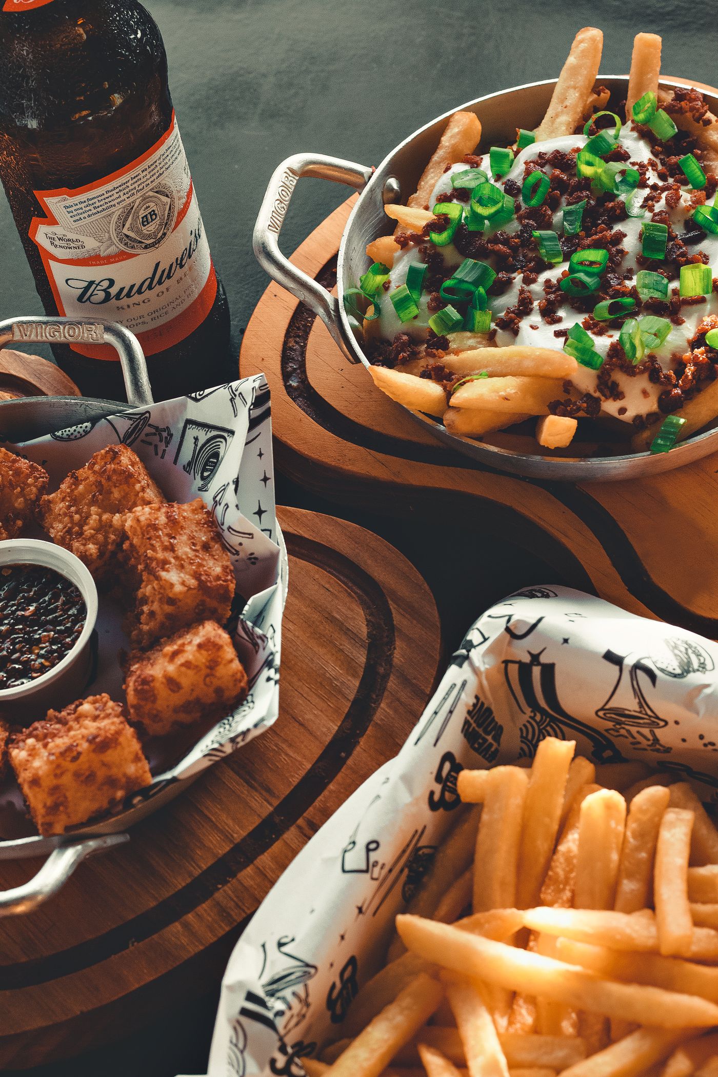 A table spread with burgers, fries, and shareable food
