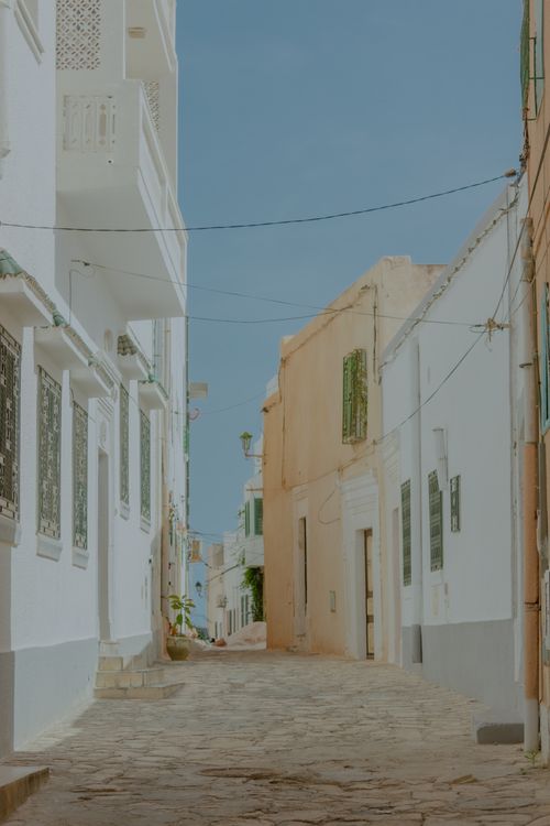 Free Serene alley scene with whitewashed walls, perfect for Mediterranean travel inspiration. Stock Photo