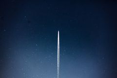 A rocket streaks through a starry night, leaving a trail in outer space.