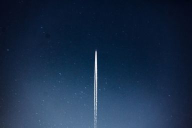 A launch streak climbing into the night sky