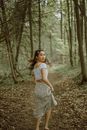 Asian woman running on pathway between trees