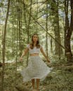 Ethnic woman standing on tree in forest