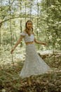 Optimistic Asian woman dancing in forest