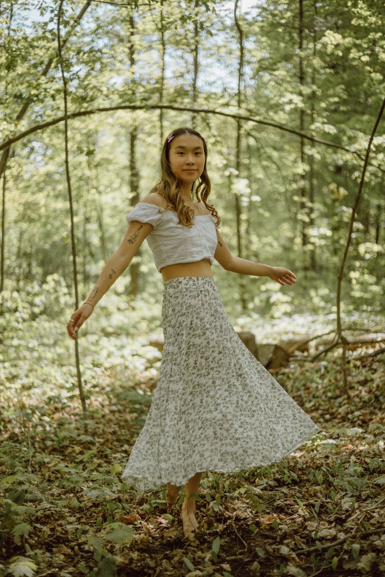 Optimistic Asian Woman Dancing In Forest