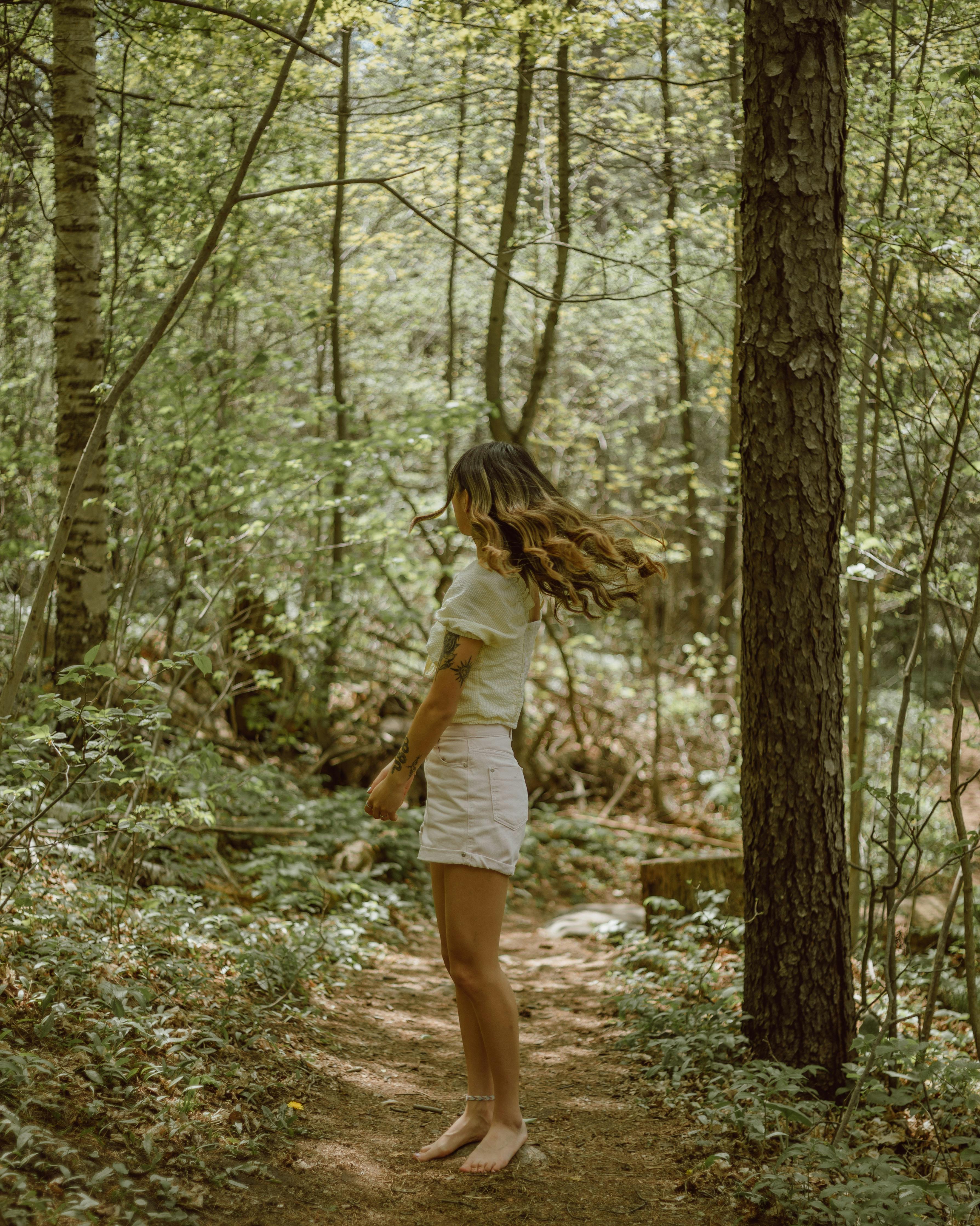Girl with long hair on walkway between trees · Free Stock Photo