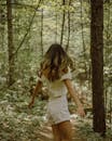 Woman with wavy hair spinning around in forest