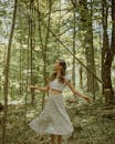 Carefree Asian woman spinning around in forest