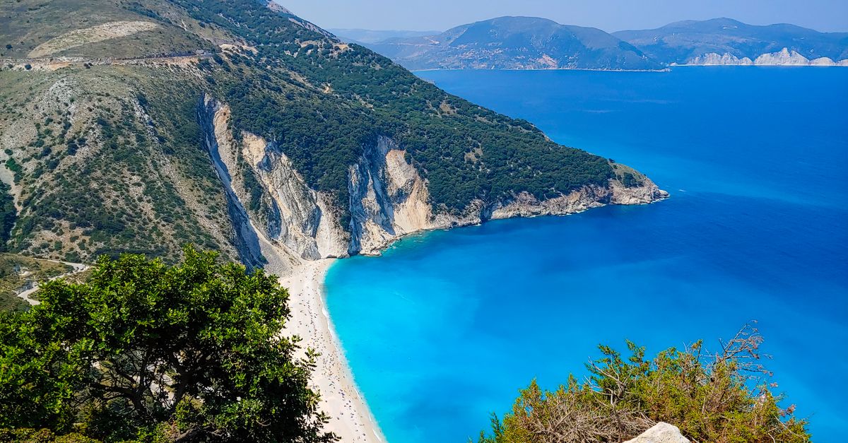 Stunning aerial view of Myrtos Beach with turquoise waters and rugged cliffs on Kefalonia Island, Greece.