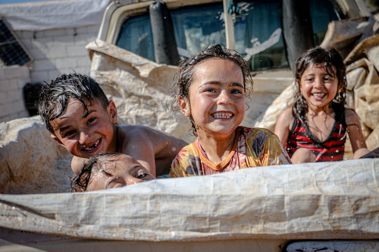 Happy Children Playing With Water Outdoors 