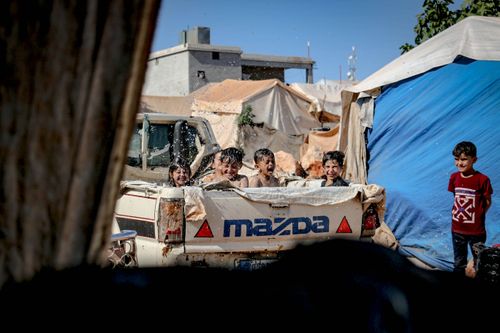 Free Kids enjoying water play in a Mazda truck in a Syrian village. Captured on a sunny day. Stock Photo