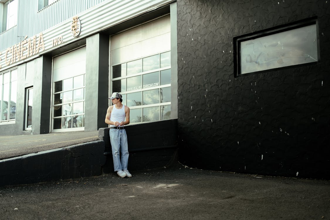 Man in White Tank Standing on a Parking Area