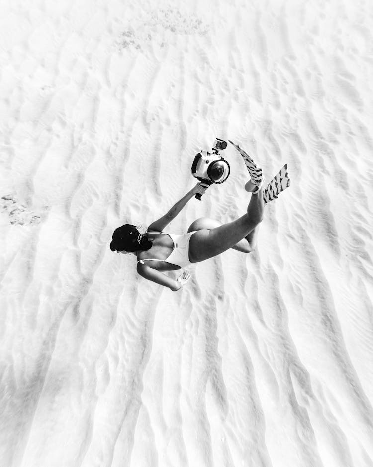 Unrecognizable Fit Woman With Camera Swimming Underwater