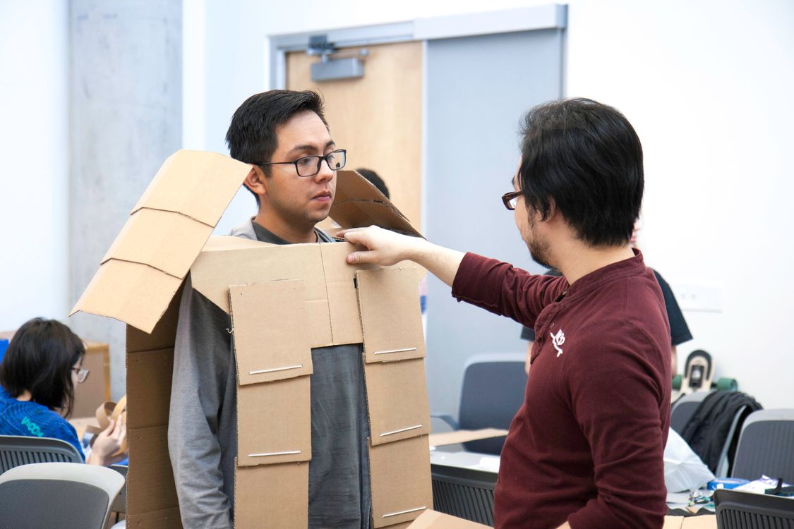 Man measuring his Colleague while wearing Cut-out Carton Boxes · Free ...