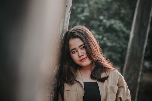 Gratis lagerfoto af asiatisk kvinde, betonmur, brun jakke