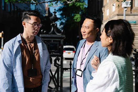 Three adults having a casual discussion outdoors during the day.