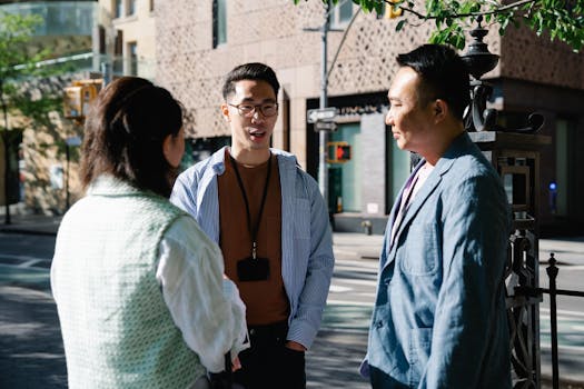 Three professionals engaged in conversation outdoors in a city backdrop.