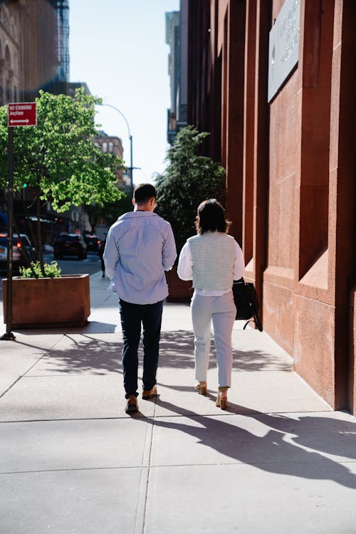 Free Man and Woman Walking on the Sidewalk Stock Photo