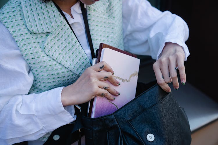 Woman Putting Stationary In Bag