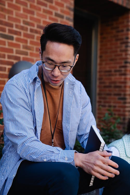 Free Man in Casual Wear Holding a Notebook Stock Photo