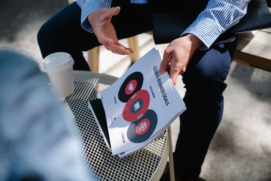 The Globalization of Prop Trading: Anyone, Anywhere Funded 3 a trader in an emerging market using a laptop with a trading chart, connected via a mobile hotspot, emphasizing remote access challenges and solutions