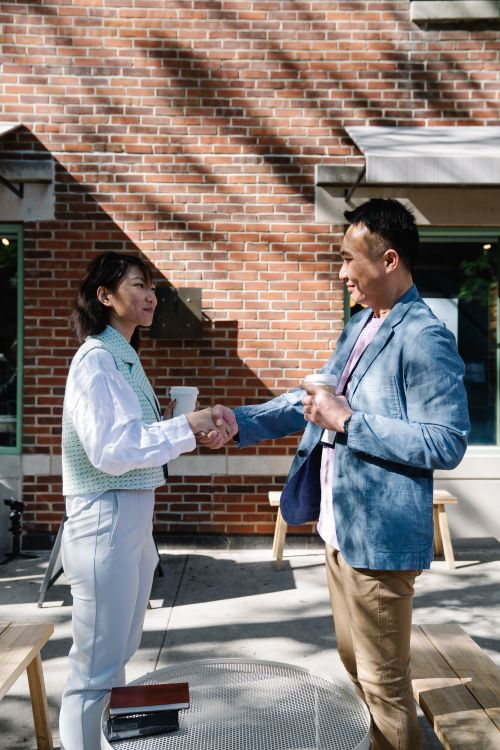 Free Business meeting handshake taking place outdoors with a casual setting. Stock Photo