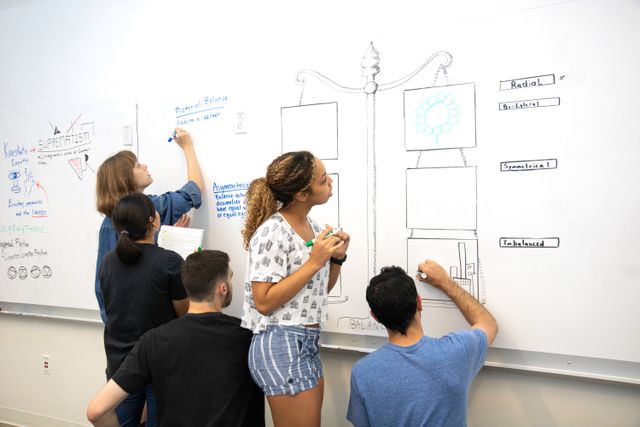 Students sketching app screens on a whiteboard