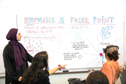 Woman in Black Shirt Writing on White Board