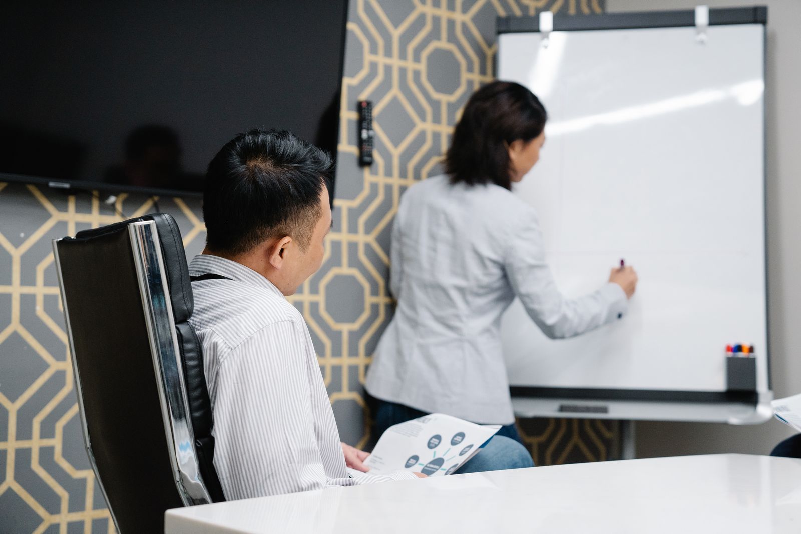 Wexley colleagues working through a plan at a whiteboard, photo by Felicity Tai on Pexels