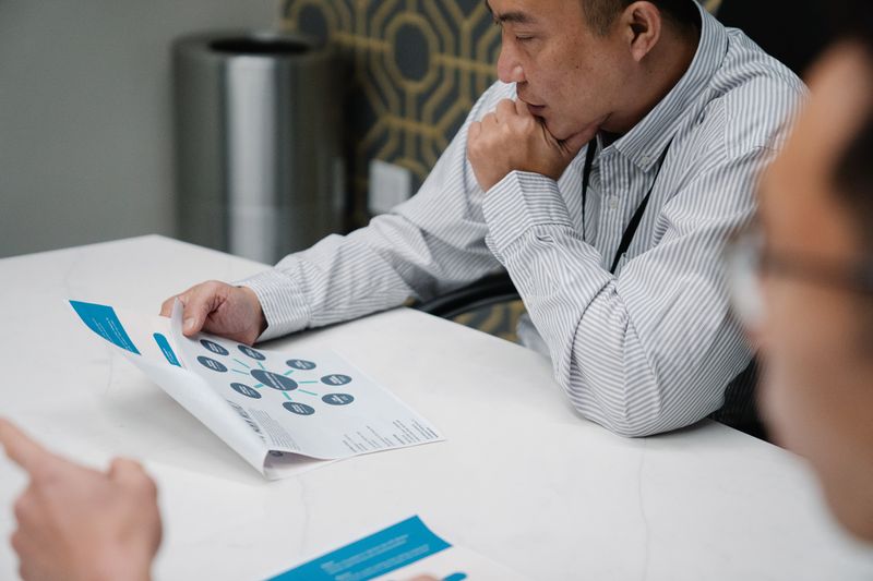 Seattle print designer comparing a brochure proof with digital artwork