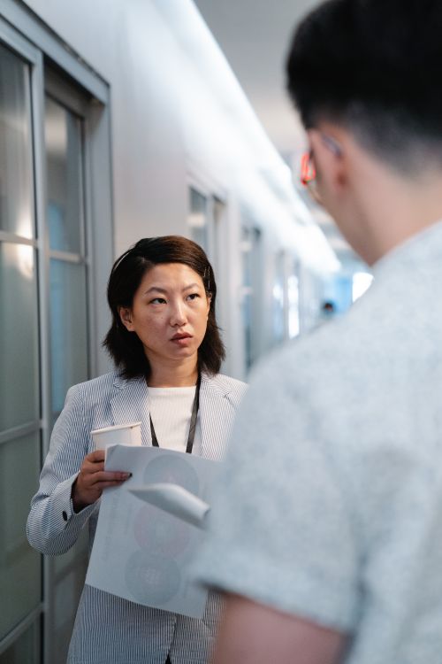 Free Two colleagues discussing work in an office hallway. Stock Photo