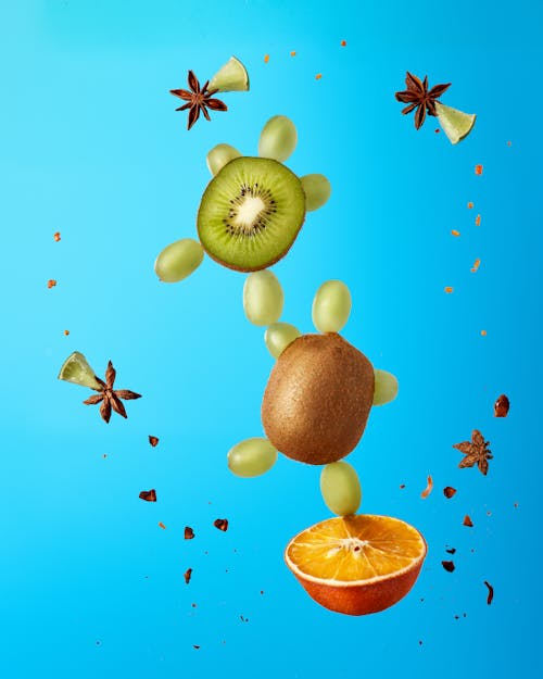 Sliced Kiwis and Oranges on Blue Surface 