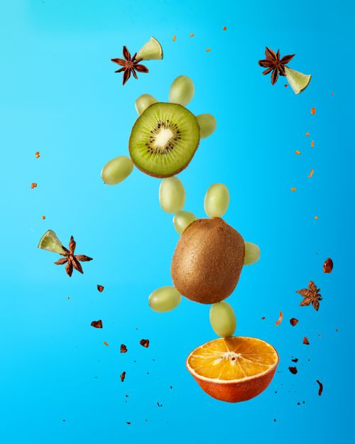 Free Vibrant composition of fresh fruits including kiwi and orange against a blue backdrop. Stock Photo